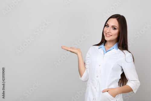 Portrait of young doctor on grey background