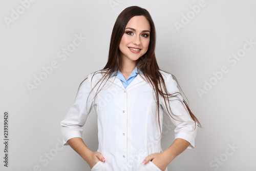 Portrait of young doctor on grey background