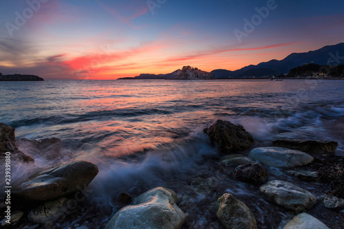 castle on an island in the sea at sunset