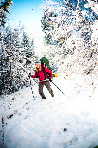 Woman with backpack and snowshoes in the winter mountains.