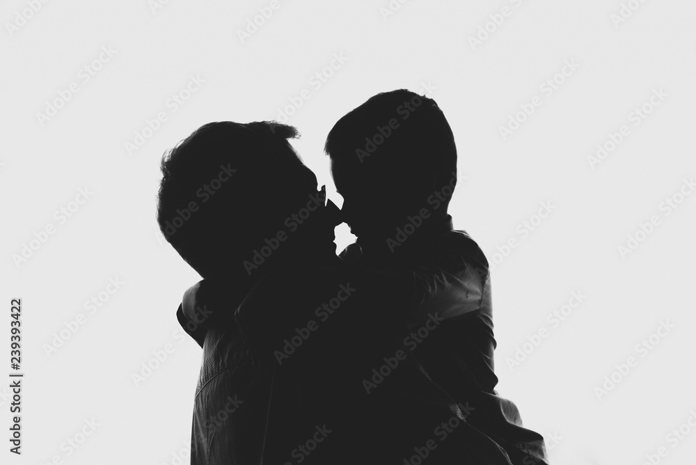 Silhouettes dads and sons standing near the window. Black and white photography