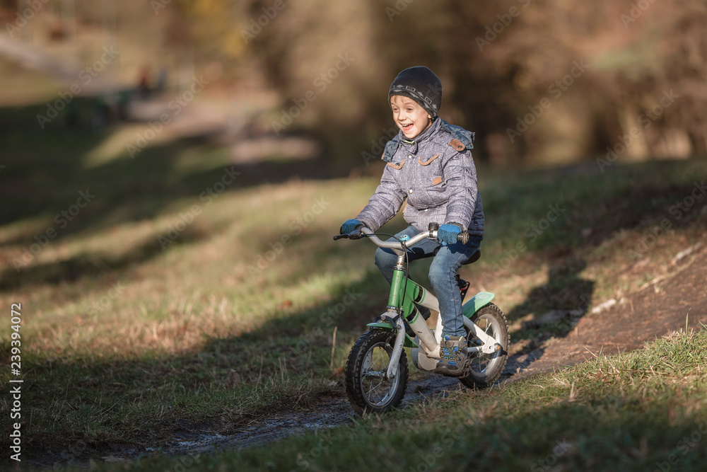 Six years old boy rides bicycle from the hill in the park. Six years old boy rides bicycle from the hill in the park.