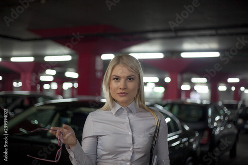 Professional gorgeous saleswoman at car dealership in formal wear.