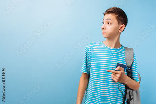 Surprised teenager looking at the camera, pointing fingers at an empty space photo