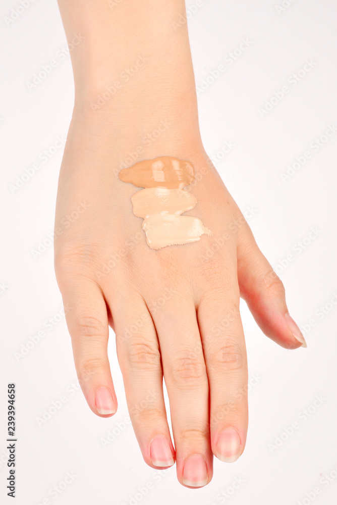 Fair, medium, dark swatches of foundation on the hand isolated on white. Fair, medium, dark swatches of foundation on the hand isolated on white.