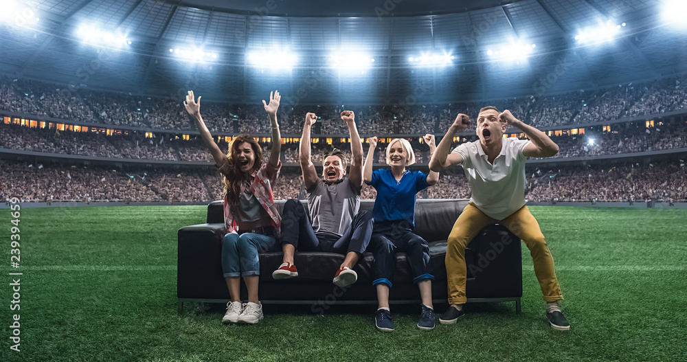Φωτογραφία Group of students are watching a soccer moment, sitting on the couch located in the middle of the soccer stadium