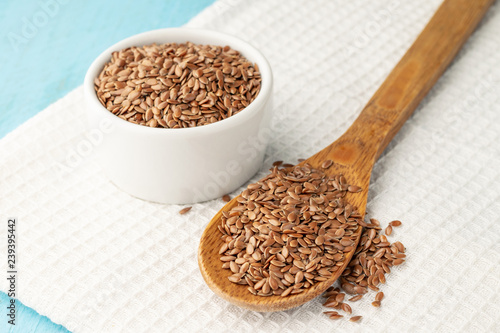 Flax seeds whole in a bowl and wooden spoon