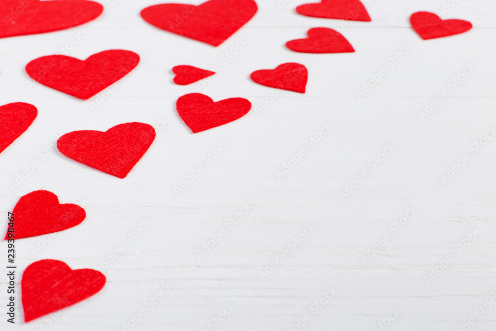 Red hearts of different sizes on a white background. Harvesting cards for Valentine's Day. Place for text, copy space.