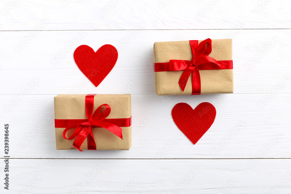Gift with red ribbon and hearts on white wooden background. Women's or Valentine's Day. Place for text, copy space. Gift with red ribbon and hearts on white wooden background. Women's or Valentine's Day. Place for text, copy space.