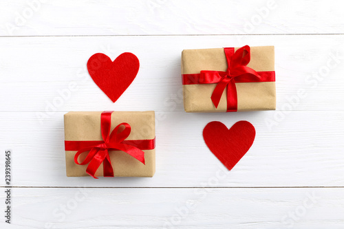 Gift with red ribbon and hearts on white wooden background. Women s or Valentine s Day. Place for text  copy space.