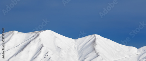 Panoramic view on snowy winter mountains and blue clear sky photo