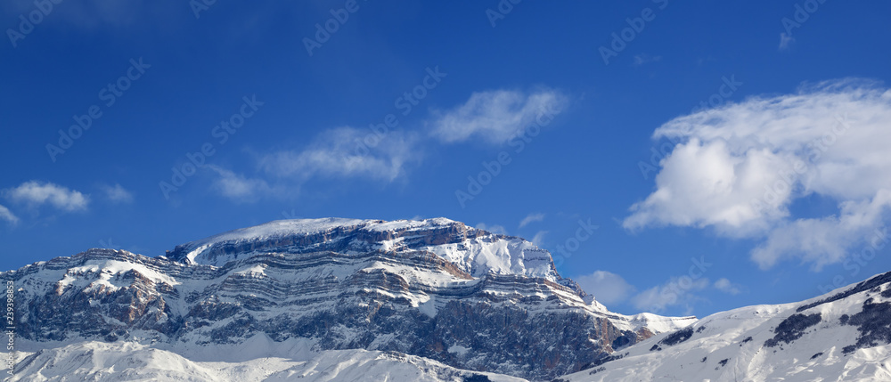 Panoramic view on rocky mountains in snow at sun winter day