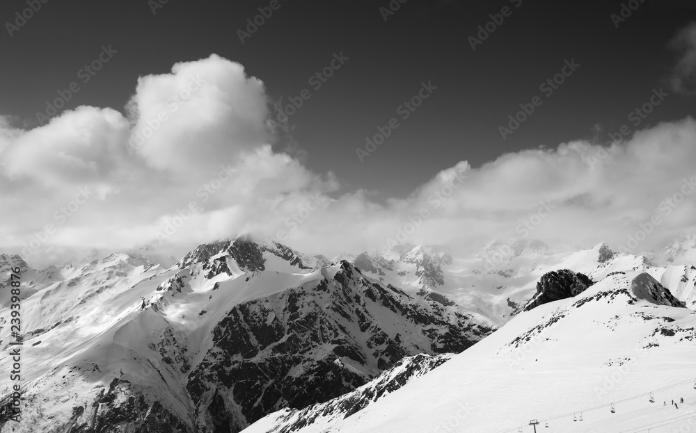 Black and white panorama of ski resort and snowy mountains
