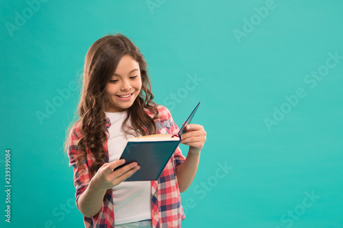 Towards knowledge. Girl hold book read story over blue background. Child enjoy study and reading book. Book store concept. Wonderful free childrens books available to read. Childrens literature