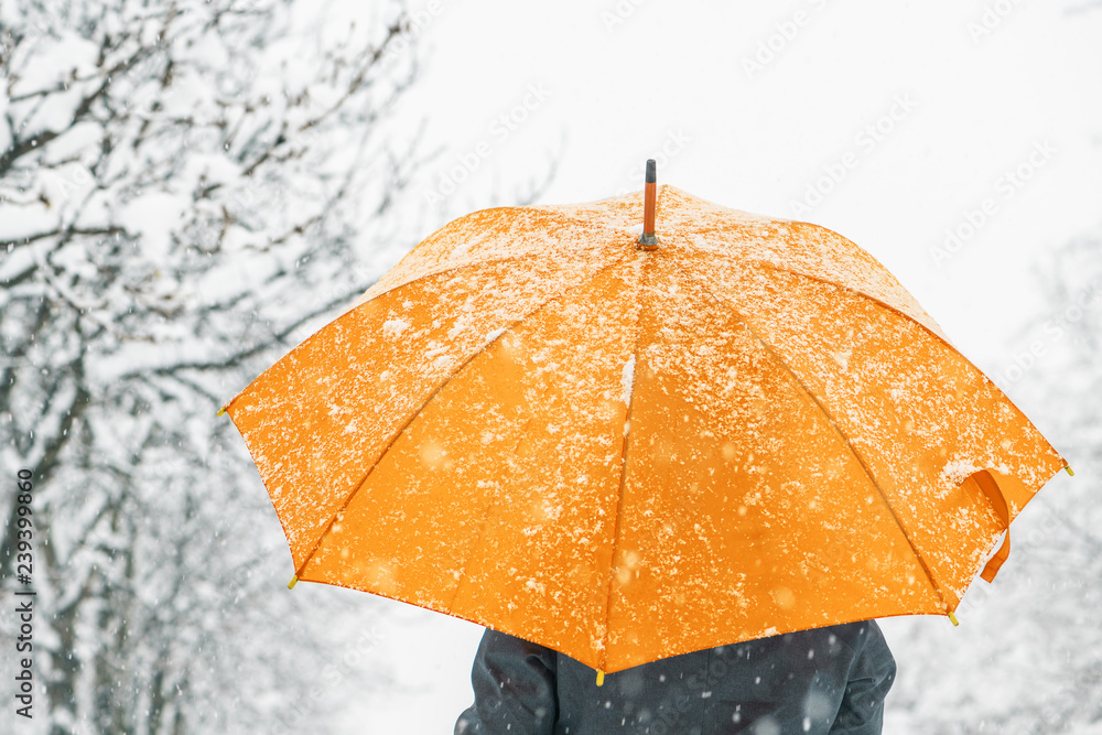Woman with yellow umbrella in snow