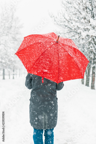 Woman with red umbrella in snow