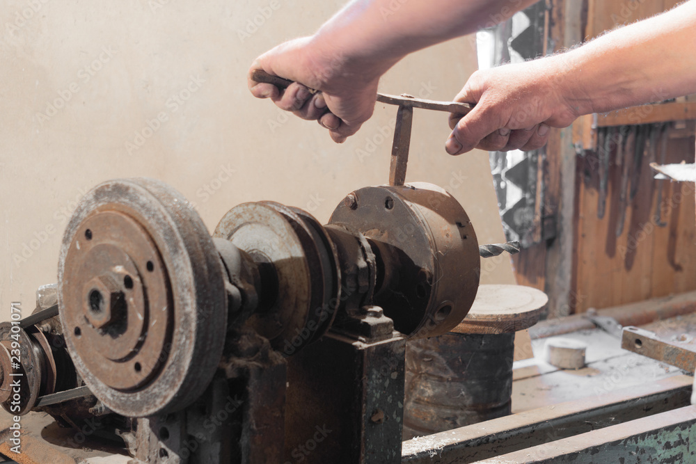 Home workshop, turner clamps a part into a lathe chuck, industry, working hands Home workshop, turner clamps a part into a lathe chuck, industry, working hands