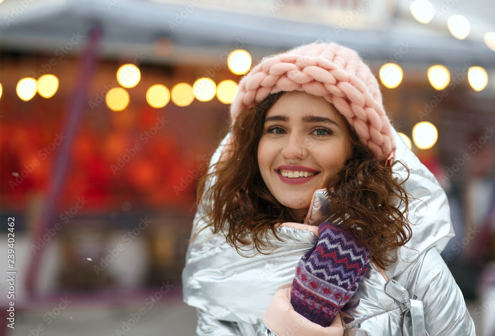 Winter portrait of positive brunette young lady wearing warm trendy outfit, walking at the Christmas fair in Kyiv. Space for text Winter portrait of positive brunette young lady wearing warm trendy outfit, walking at the Christmas fair in Kyiv. Space for text