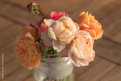 Bouquet of English roses with hoarfrost on the petals on the old wooden table, rustic style. © Olga Ionina