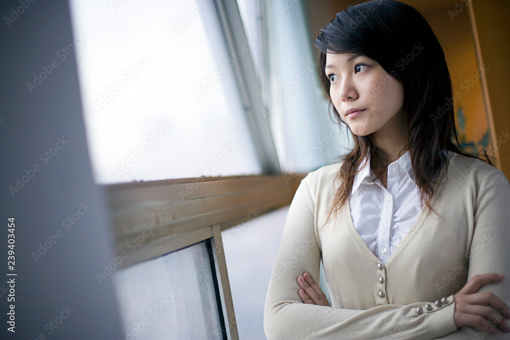 © Erickson Stock - Young businesswoman standing with her arms crossed. © Erickson Stock - Young businesswoman standing with her arms crossed.