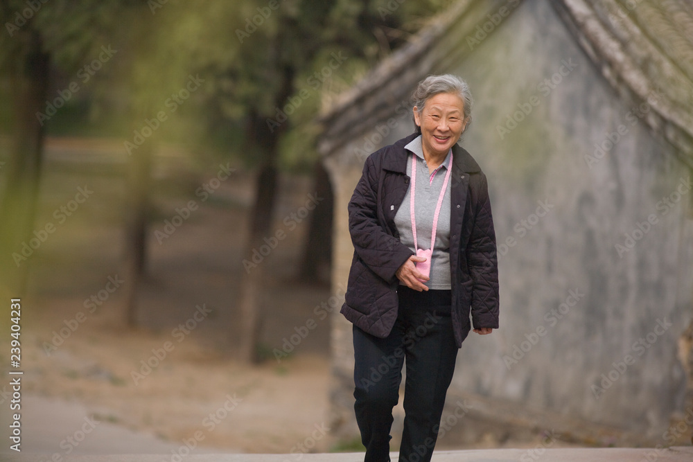 Portrait of a senior woman walking along a road. Portrait of a senior woman walking along a road.