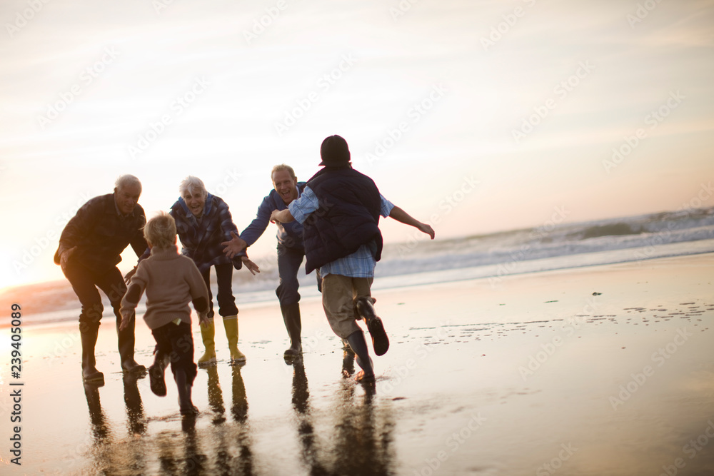 Two boys running to embrace their family on a beach Two boys running to embrace their family on a beach