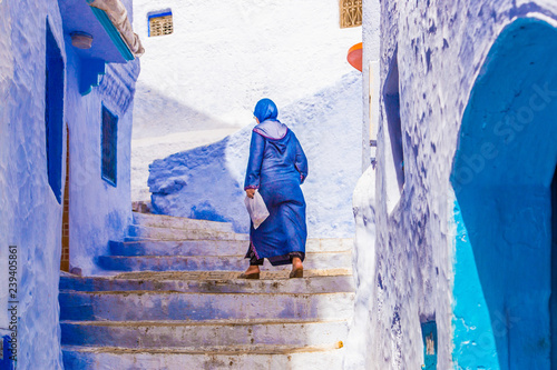 Moroccan women going up stairs in narrow Chefchaouen streets, Morocco © matiplanas