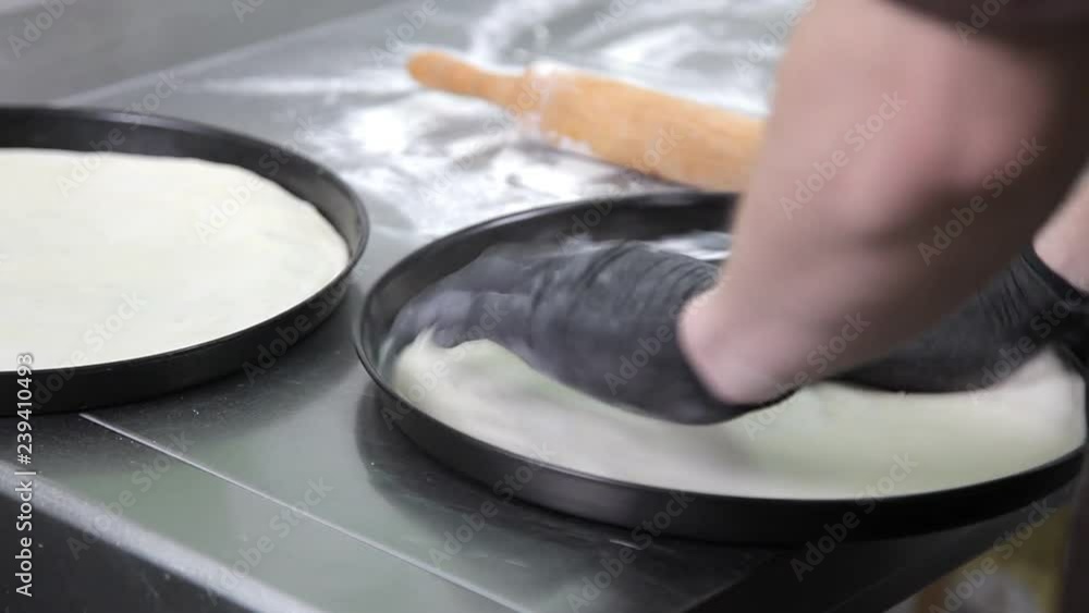 close up. Cook with gloves in preparing pizza in a restaurant kitchen close up. Cook with gloves in preparing pizza in a restaurant kitchen