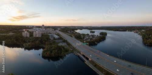 Aerial panoramic view of a Highway in the Modern City during a vibrant Sunset. Taken in Halifax, Dartmouth, Nova Scotia, Canada.