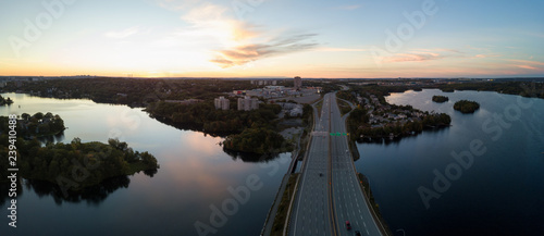 Aerial panoramic view of a Highway in the Modern City during a vibrant Sunset. Taken in Halifax, Dartmouth, Nova Scotia, Canada.