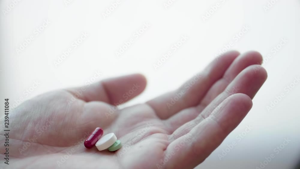 Man is Taking Medicine: Different Medical Pills, Tablets, Capsules and Drugs Falling in a Hand in Slow Motion Man is Taking Medicine: Different Medical Pills, Tablets, Capsules and Drugs Falling in a Hand in Slow Motion