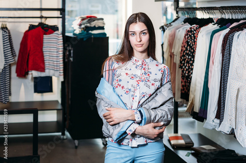 shopping, fashion, style, sale, shopping, business and people. concept beautiful happy young woman in a clothing store. the business owner is a clothing store. businesswoman