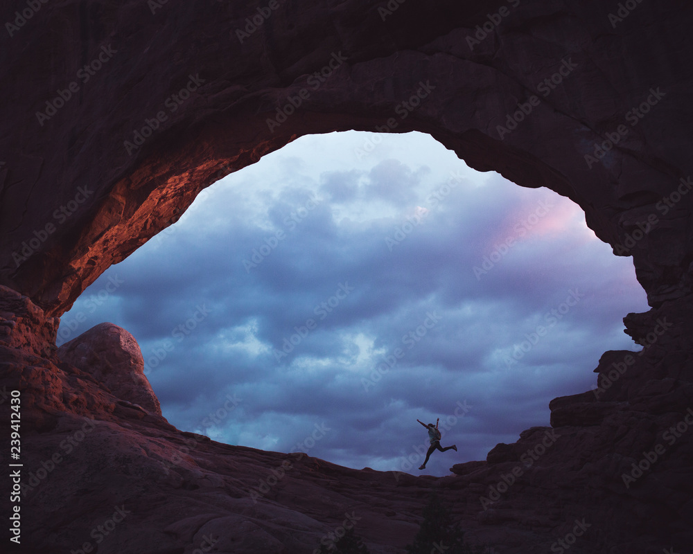 A woman jumps off a rock formation in Utah