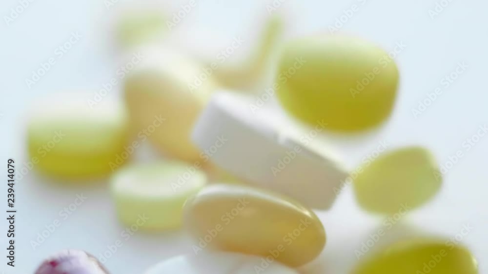 A lot of Macro Colorful Medical Pills, Tablets, Capsules and Drugs Falling to a White Background A lot of Macro Colorful Medical Pills, Tablets, Capsules and Drugs Falling to a White Background