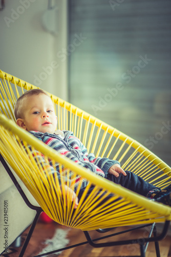 Happy baby boy lying in chair © qunica.com