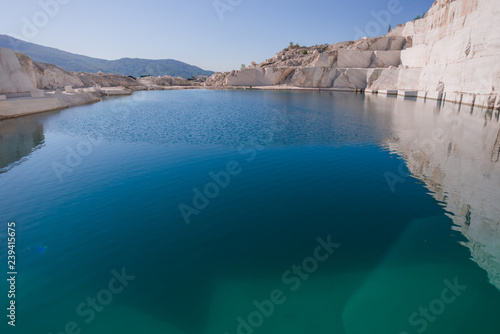 Marble quarry landscape in the mountains with a turquoise lake water