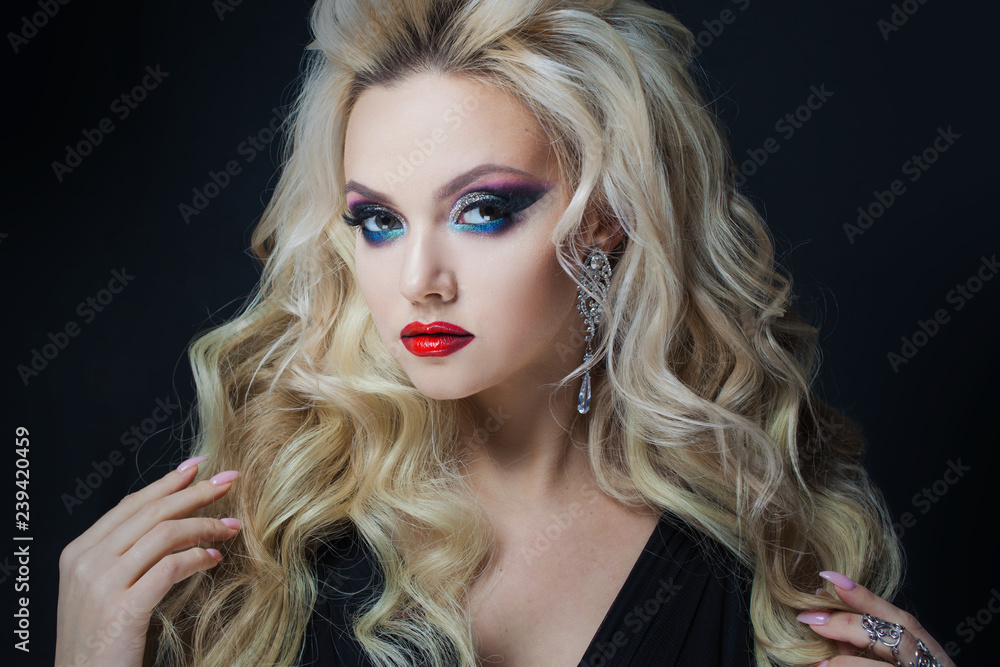 Fototapeta premium Portrait of a young luxurious blonde with long curls.