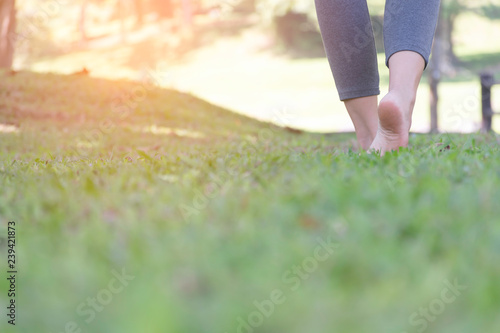 girl barefoot walking on green grass
