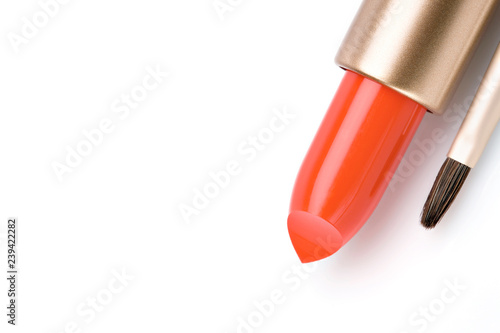 Coral lipstick and make-up brush.