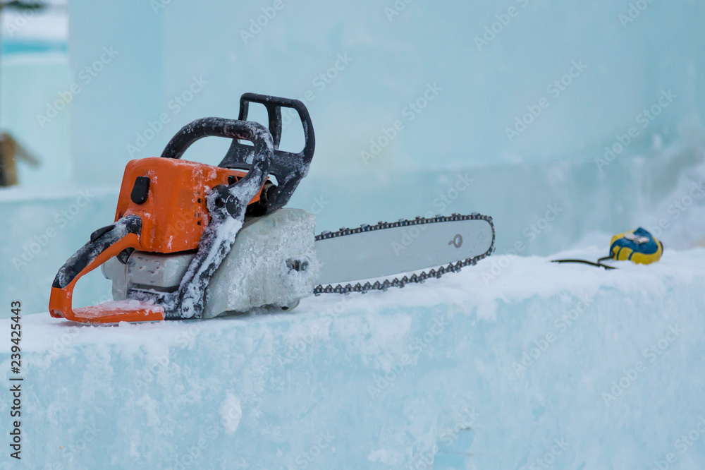 Chainsaw and tape measure on the ice block