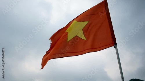 Vietnam flag waving in a cloudy day in Halong Bay photo