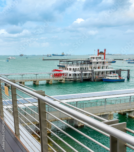 Boardwalk by harbor with ships