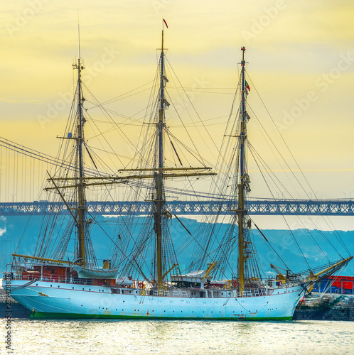 Ship by bridge at sunset