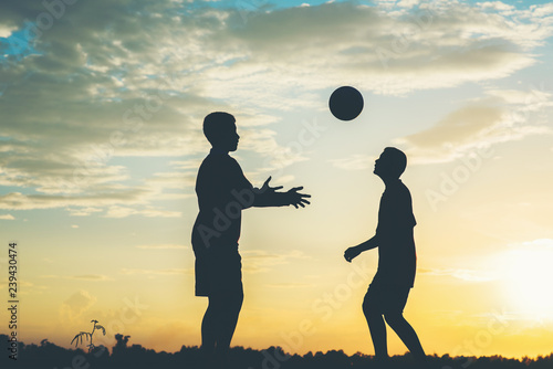 Silhouette of children play soccer football