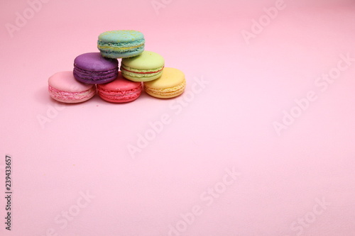 Colorful cake macaron or macaroon on pink background from front view, colorful almond cookies, pastel colors, vintage card