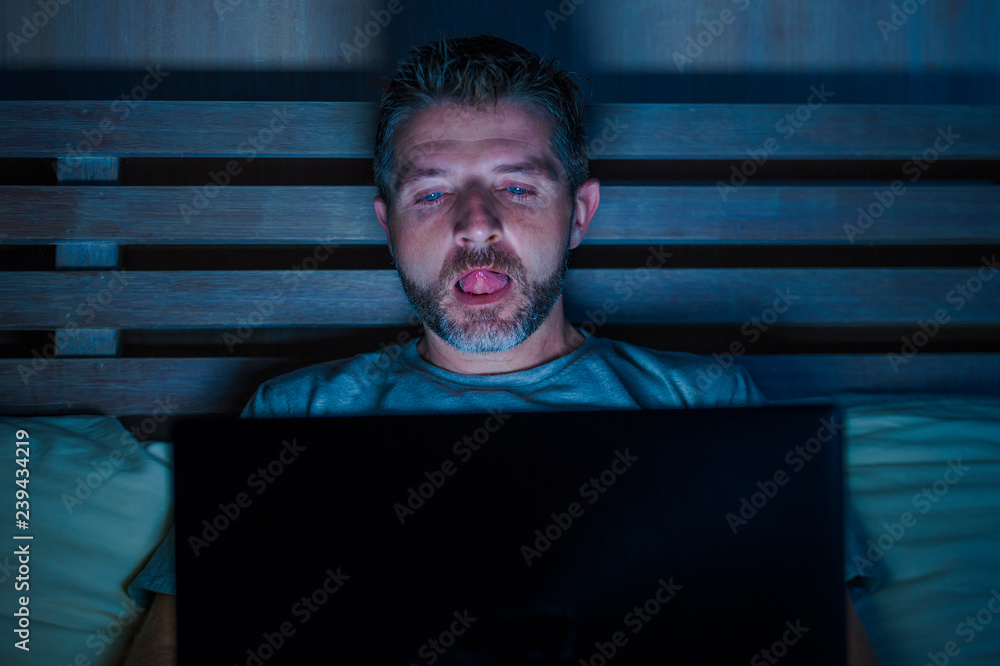 man alone in bed playing cybersex using laptop computer watching porn sex  movie late at night with lascivious pervert face expression in internet  pornographic sexual content foto de Stock | Adobe Stock