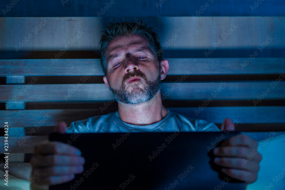 man alone in bed playing cybersex using laptop computer watching  