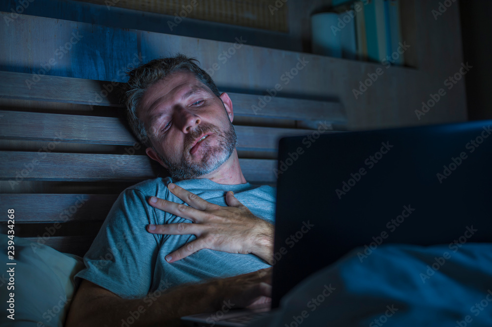 man alone in bed playing cybersex using laptop computer watching porn sex  movie late at night with lascivious pervert face expression in internet  pornographic sexual content Stock-foto | Adobe Stock