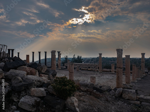 Sun shinning through the clouds over Roman ruins