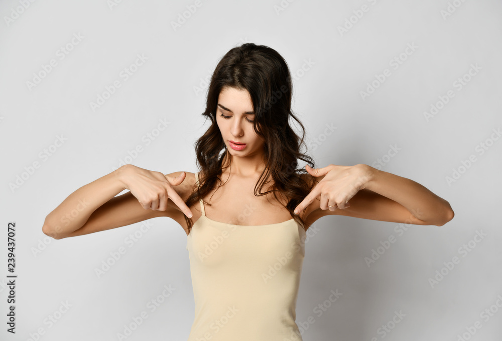 Portrait of young woman pointing fingers at her breast chest with free text  copy space Stock Photo